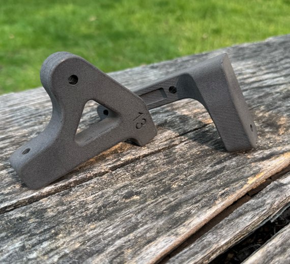 Final Nylon 12 printed bicycle brake calipers on wood bench