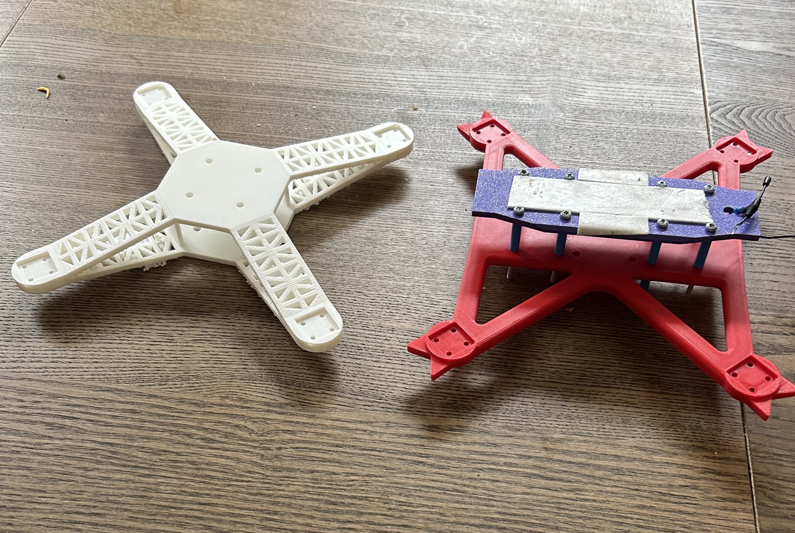 Physical baseline and redesigned quadcopter frames side by side